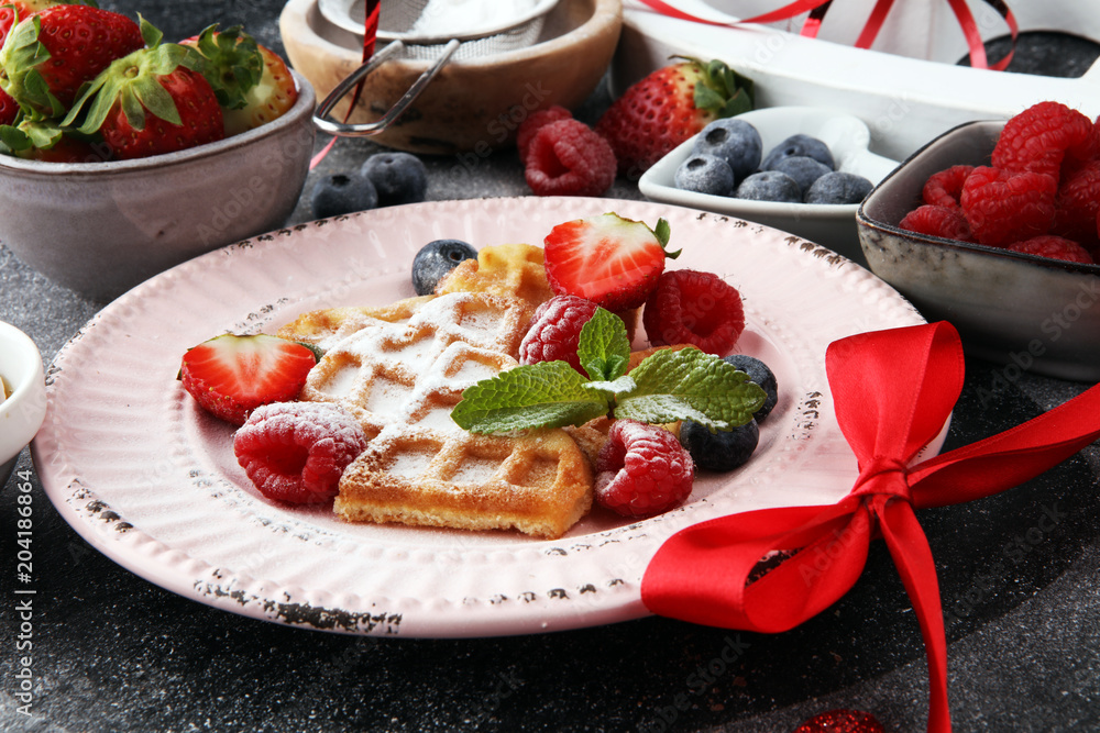 Traditional belgian waffles with fresh fruit and powder sugar on wooden board Traditional belgian waffles with fresh fruit and powder sugar on wooden board