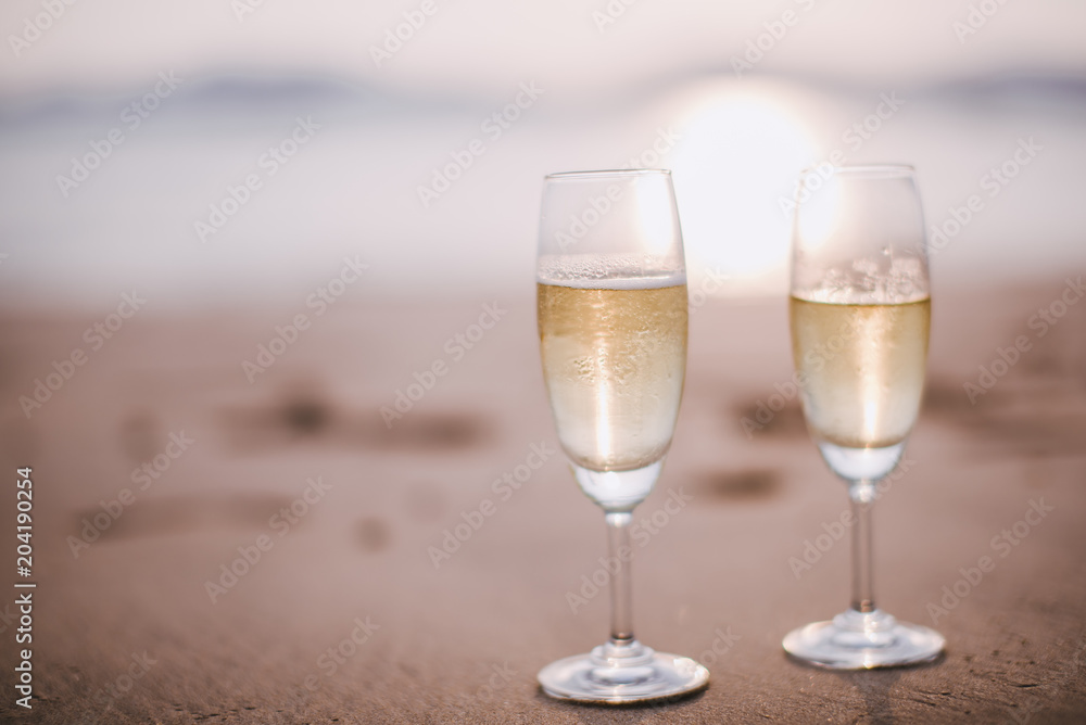 Two champagne glasses on the beach at sunset. Two champagne glasses on the beach at sunset.