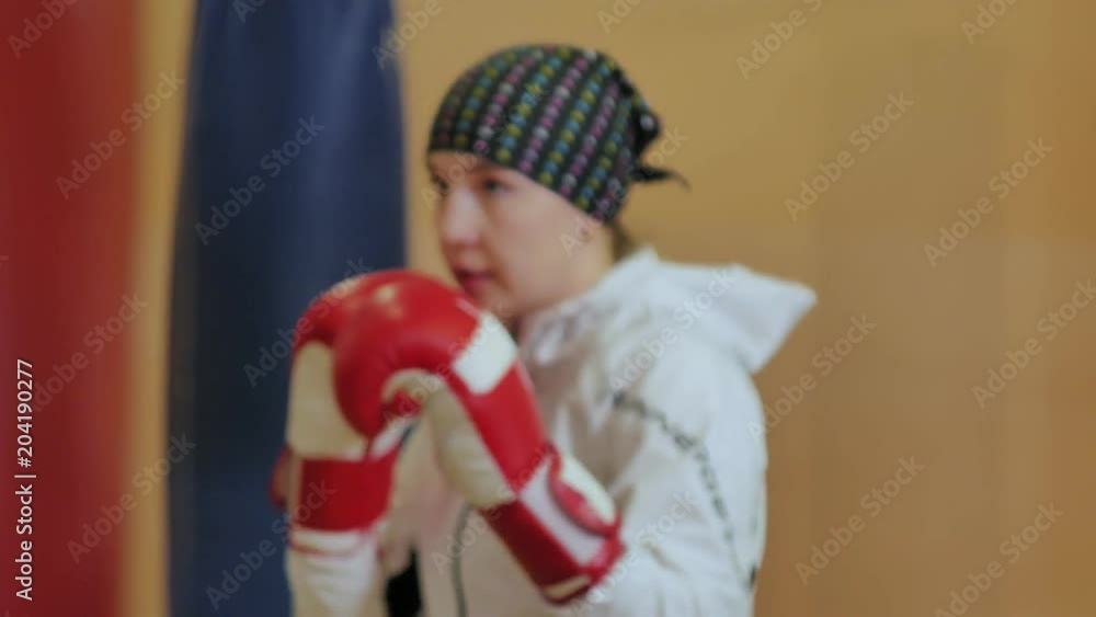 Boxing woman training punching bag in fitness studio fierce strength fit body kickboxer series Boxing woman training punching bag in fitness studio fierce strength fit body kickboxer series