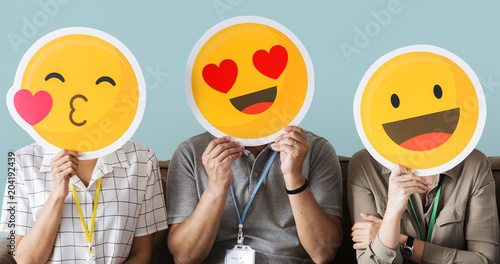 Cheerful people holding emoticon icon photo