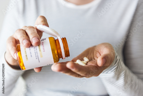 Sick woman taking pills from bottle photo