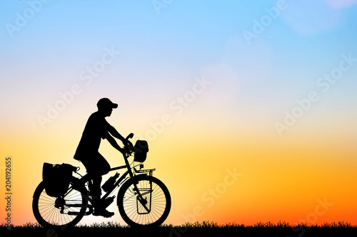 Silhouette man and bike relaxing on sunrise © rathchapon