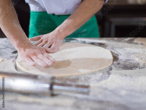 chef preparing dough for pizza