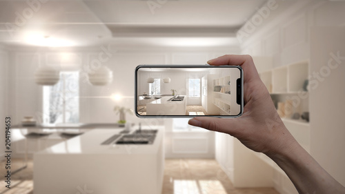 Hand holding smart phone  AR application  simulate furniture and interior design products in real home  architect designer concept  blur background  modern kitchen