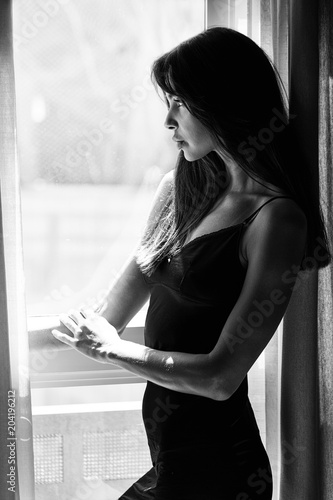 Sexy woman looking out of window in lingerie