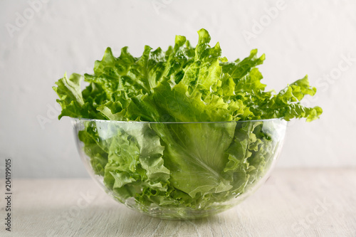 lettuce leaves in glass bowl on white background