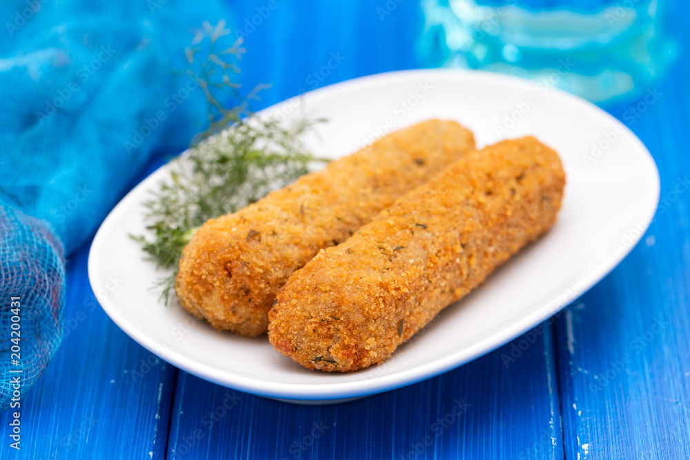 chicken croquetes on white dish on blue wooden background chicken croquetes on white dish on blue wooden background