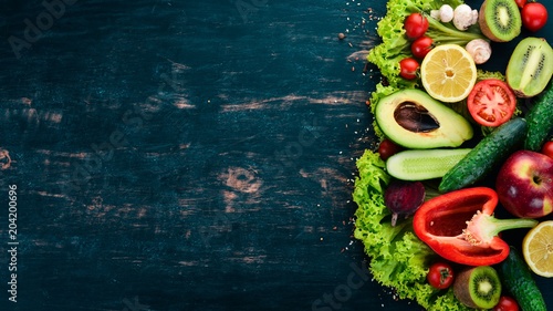 Healthy food. Vegetables and fruits On a black wooden background. Top view. Copy space.