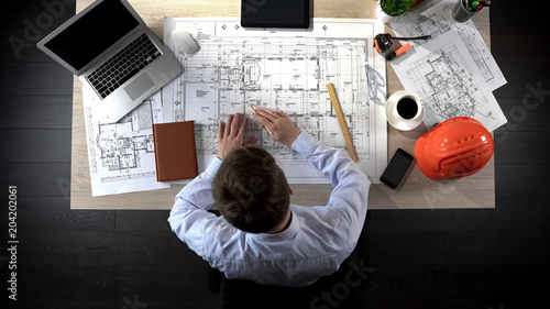 Foto Representative of construction company preparing drawing of office building