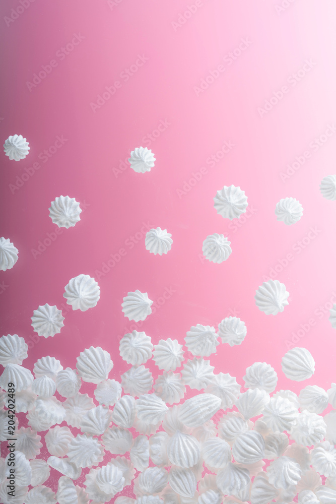 French vanilla meringue cookies on pink background with copy space.