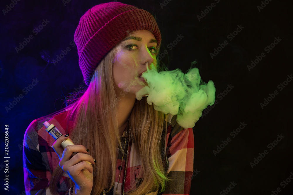 Vaping girl. Young hipster woman vape e-cig on studio on black background.  Hip-hop style. Close up. Stock Photo | Adobe Stock