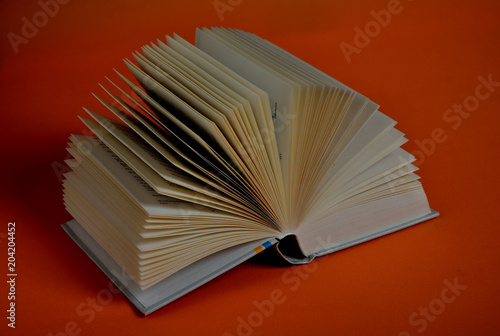 Open Book forming a fan on orange background