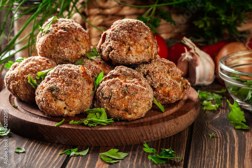 Stack of baked meatballs on a chopping board photo