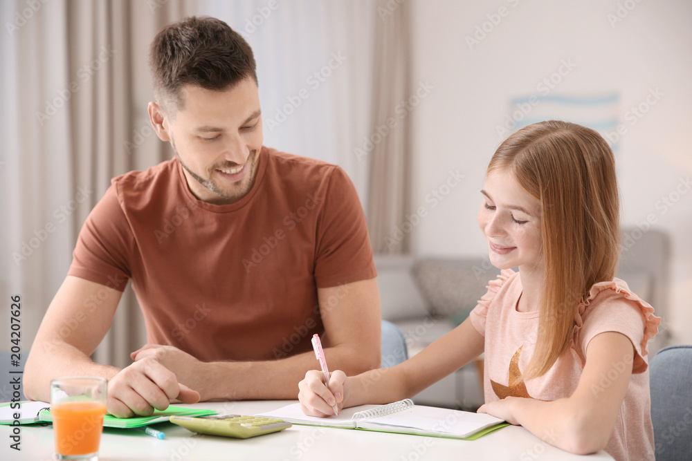 Cute little girl doing homework with father Cute little girl doing homework with father