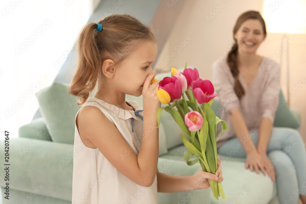 Cute little girl with bouquet of flowers for her mother at home Cute little girl with bouquet of flowers for her mother at home