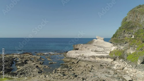 Natural rock formation of limestone stone on the coast. Aerial view of tourist attraction Kapurpurawan Rock Formation in Ilocos Norte Philippines,Luzon. photo