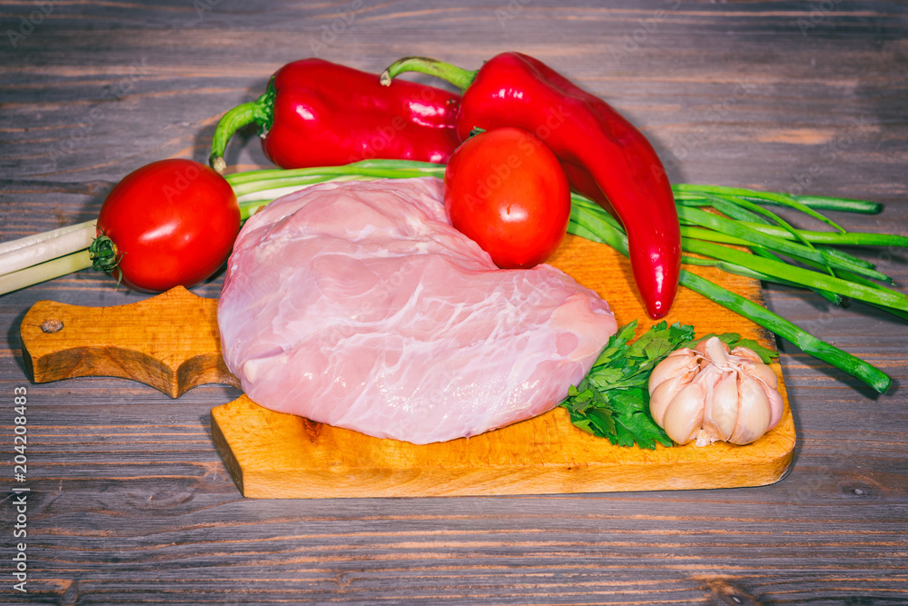 Fresh raw veal meat with vegetables on wooden background Fresh raw veal meat with vegetables on wooden background