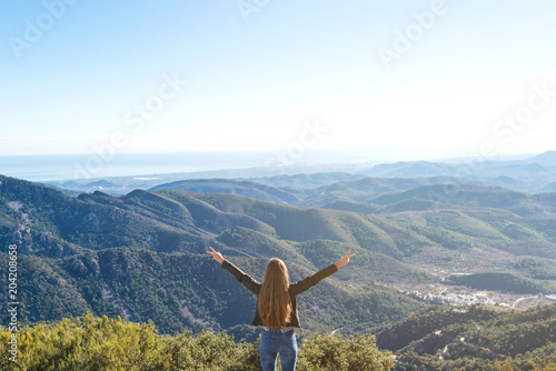 Beautiful women showing peace sign while enjoying mountains landscape