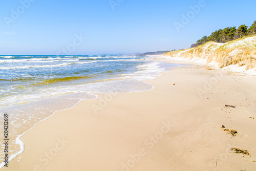 Hagestad nature reserve in Loderup, Sweden - Lovely sandy beach with waves rolling in from the sea on a sunny day.