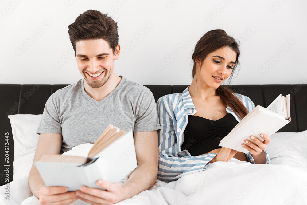 Happy young couple reading books
