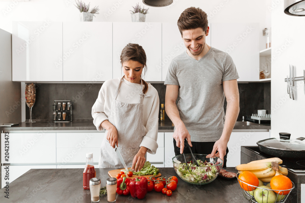 Portrait of a happy young couple cooking salad Portrait of a happy young couple cooking salad