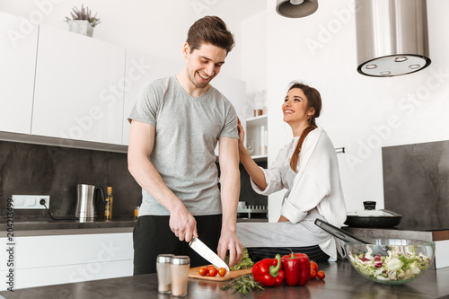 Portrait of a joyful young couple cooking together