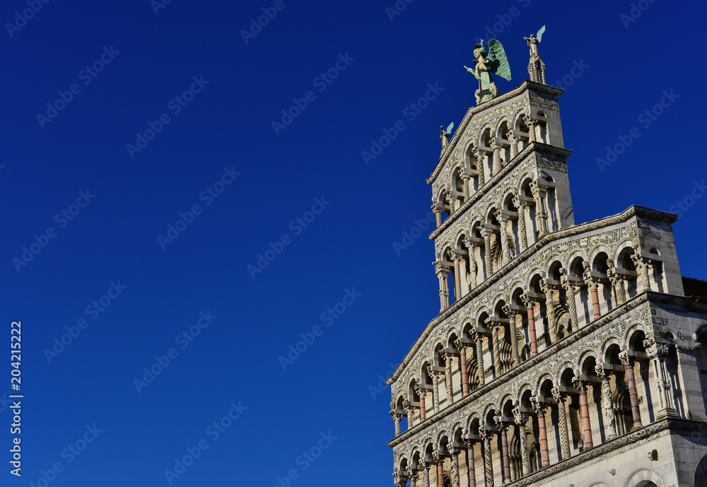 Saint Micheal in Foro Church beautiful medieval romanesque facade in the city of Lucca, Tuscany, erected in the 13th century (with blue sky and copy space)