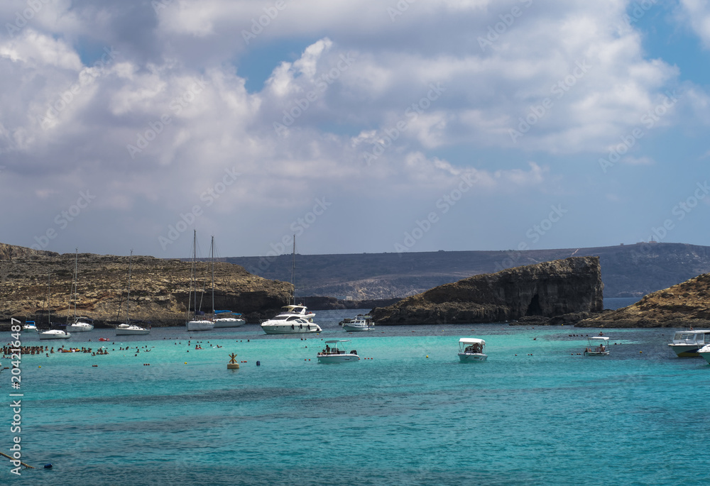 Comino Island, Malta pleasure boats moored at the Blue Lagoon. The most famous and crowded beach in Malta with crystal clear waters.