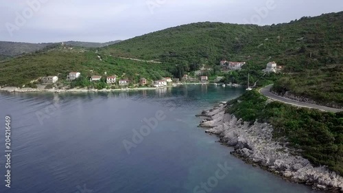 Aerial: Flying along coastline of beautiful Adriatic island Vis in Croatia. Green island with rocky shores and beautiful blue sea.