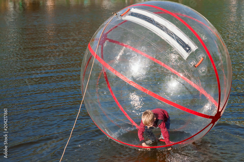 Attraction on the water, ZORB, the boy in a bowl on the water. Water attractions, rest, vacation, vacation. photo