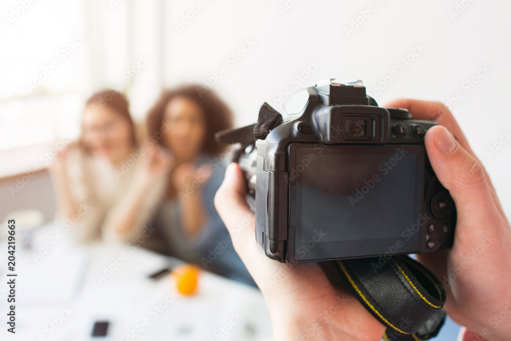 Close up of camera that is ready to take a picture of two beautiful girls. Somebody's hands are hold it. Close up of camera that is ready to take a picture of two beautiful girls. Somebody's hands are hold it.