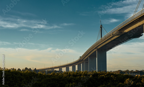 Westgate bridge in Melbourne on a beautiful, sligthly cloudy monrning, lit by the golden Australian sun.