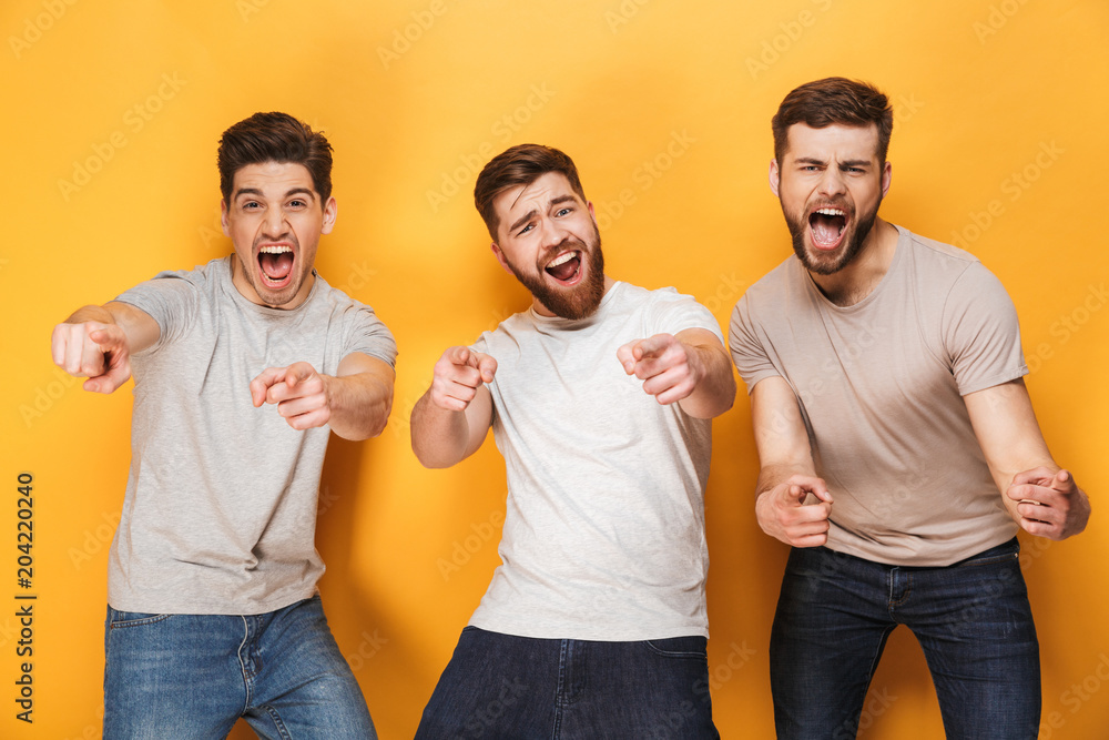 Three young happy men pointing at camera Three young happy men pointing at camera