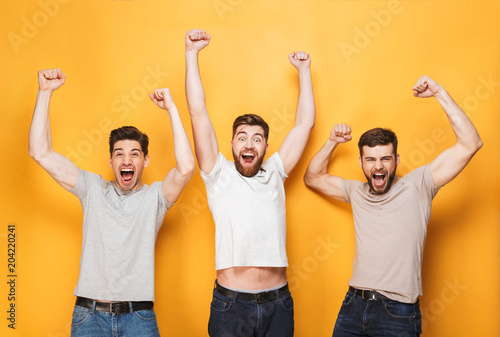 Three young excited men celebrating success © Drobot Dean