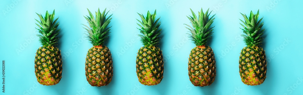 Bright pineapple pattern for minimal style. Top View. Pop art design, creative concept. Copy Space. Fresh pineapples on blue background.