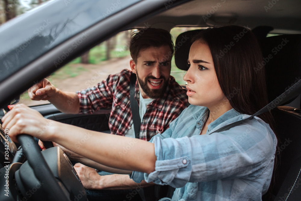 Angry and upset man is screaming and yelling at his girlfriend. He is very emotional. Girl is afraid of him. Female model is looking on the road Angry and upset man is screaming and yelling at his girlfriend. He is very emotional. Girl is afraid of him. Female model is looking on the road