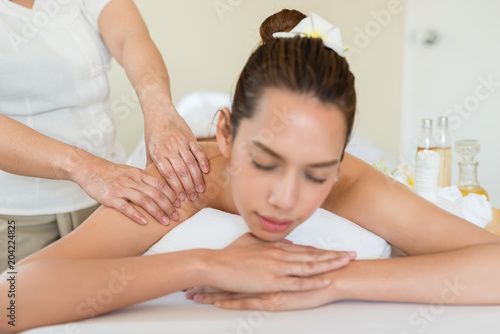 Young beautiful Asian woman a smile happy sleep relaxing in the Oil spa massage in salon. Select focus hand of masseuse