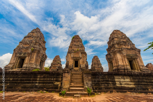 Great front view of the inner sanctuary of Cambodia s East Mebon temple. The staircase entrance  guarded by two lion statues  leads to the top level of the five prasats  towers .