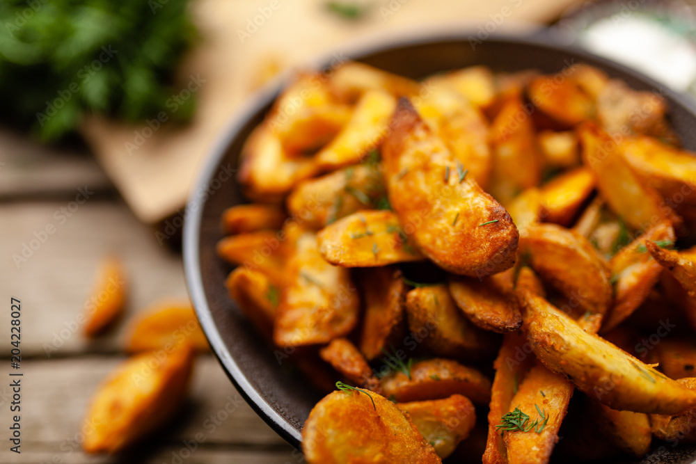 Baked potato fries on wooden table Baked potato fries on wooden table