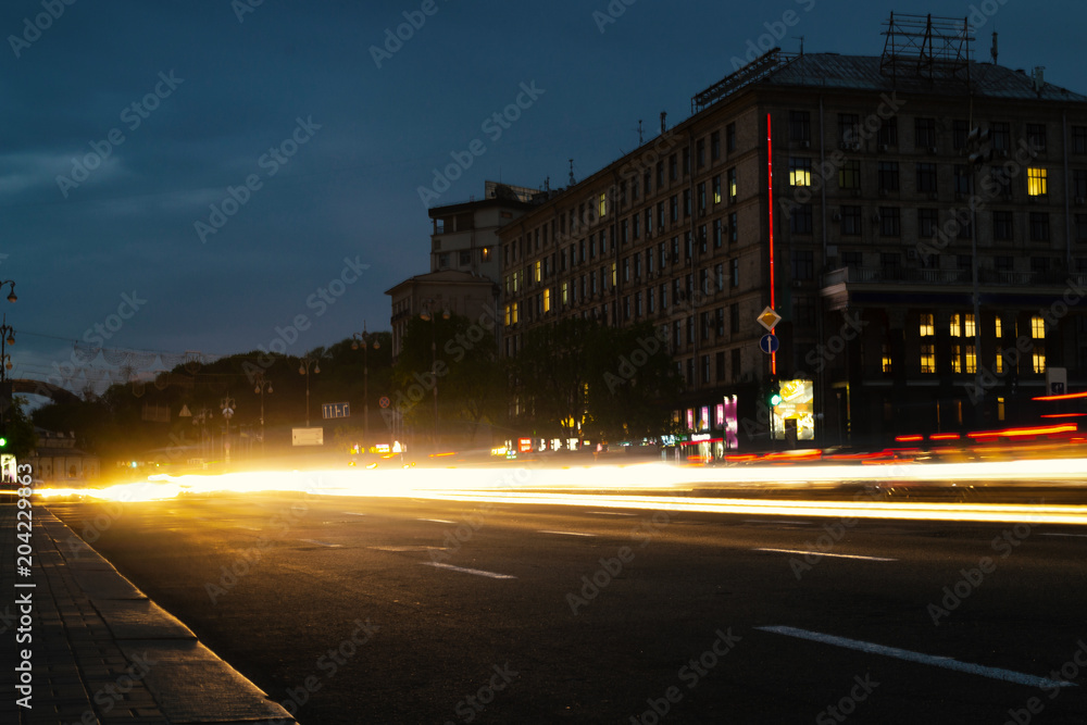 Road in the night city with light trails