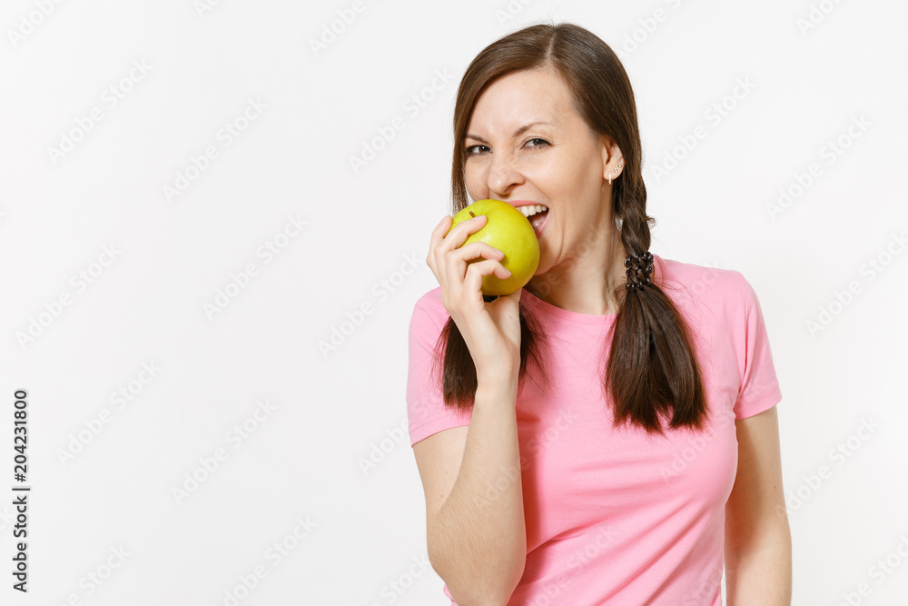 Beautiful smiling young woman with pigtails in pink t-shirt holding in hands green apple isolated on white background. Proper nutrition, dieting concept. Copy space for advertisement. Advertising area Beautiful smiling young woman with pigtails in pink t-shirt holding in hands green apple isolated on white background. Proper nutrition, dieting concept. Copy space for advertisement. Advertising area