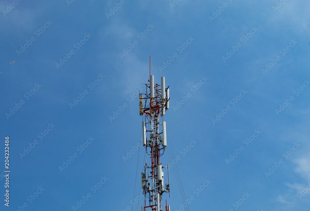 Wave transmission mast, large phone signal with a bright blue sky.