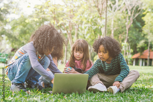 group of kids with laptop. happy children in nature with group of friend