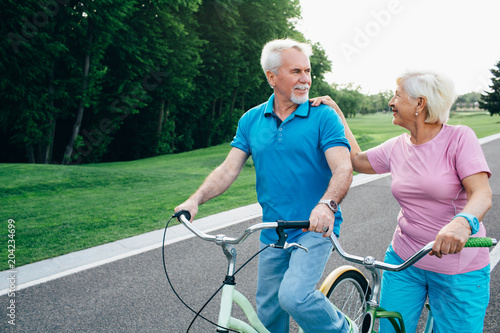 Senior Couple With Their Bicycles on green park © Peakstock