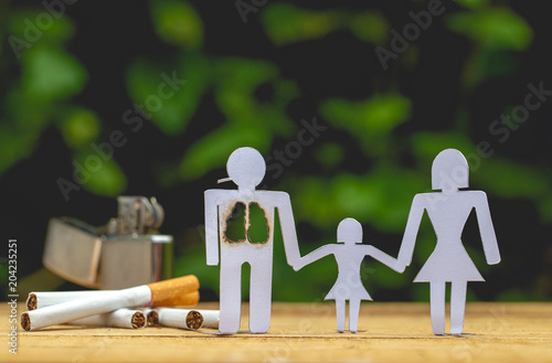 Paper dolls, parents and daughter. Daddy doll have burned lungs. Their hands hold hands with their daughter. There are Lighters and cigarettes.