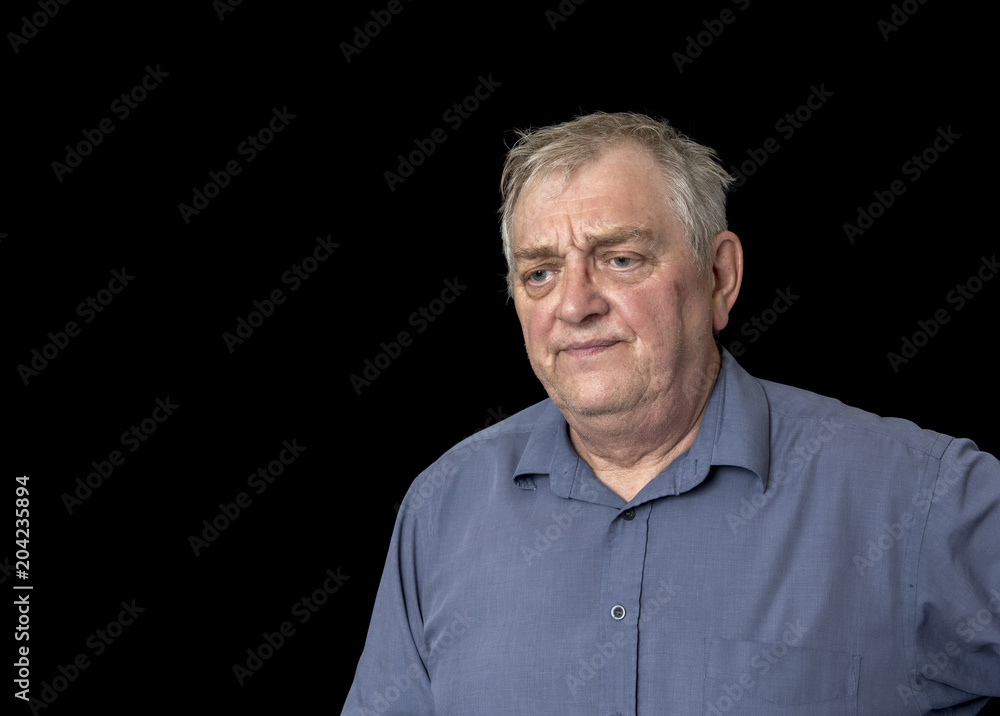 Mature man looking worried and fed up, taken on a black background Mature man looking worried and fed up, taken on a black background