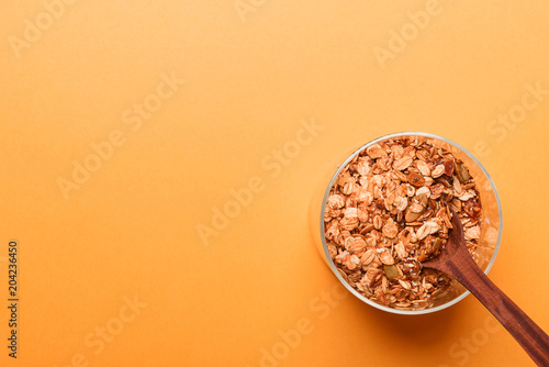 Granola in a glass jar on a yellow background