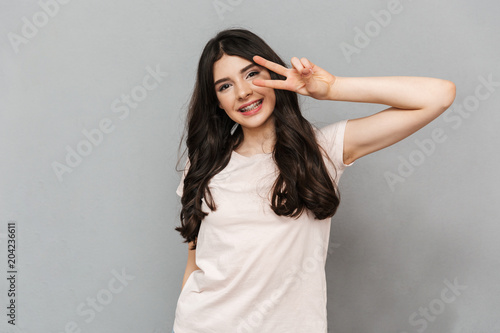 Pretty cute young lady showing peace gesture.
