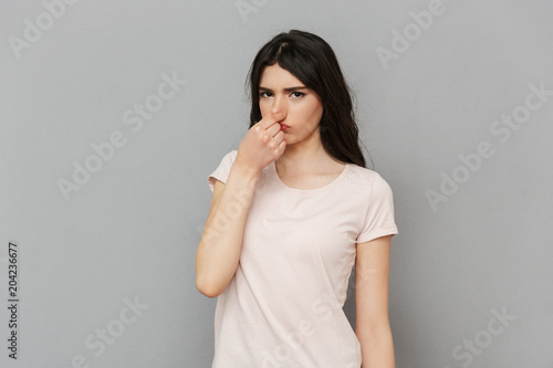 Displeased young lady covering his nose.