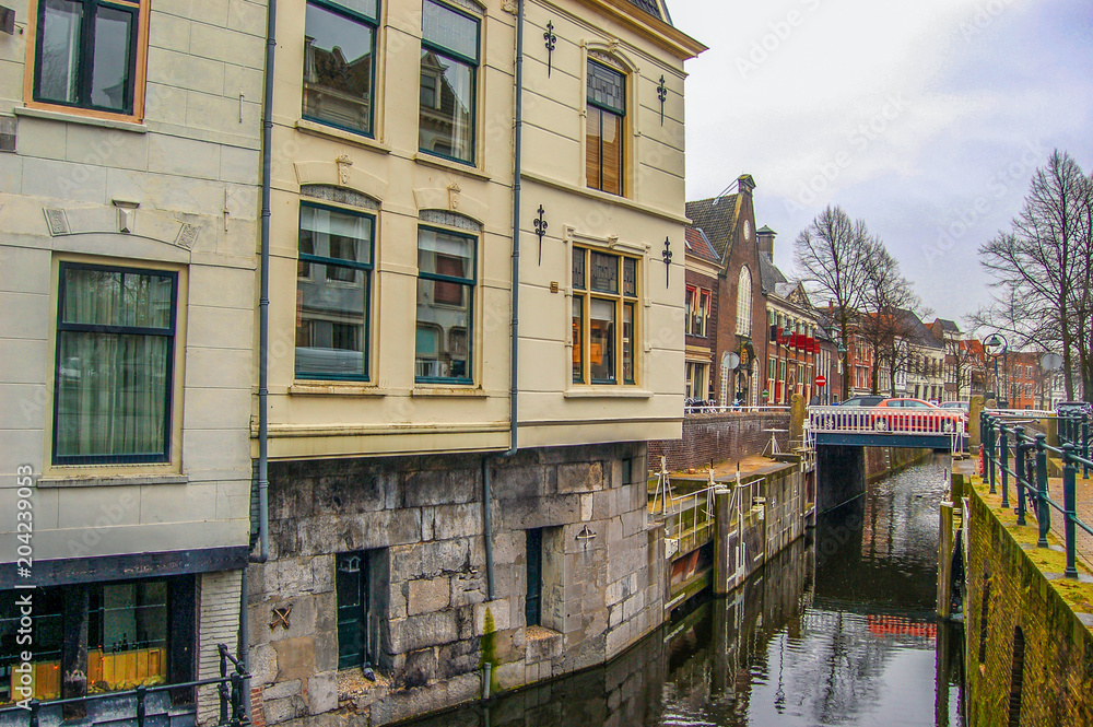 Canal with bridge and monumental houses. Gouda, the Netherlands.